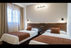 莫萨韦斯莫萨韦斯萨拉曼卡酒店的酒店客房设有两张床和窗户。