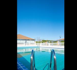 莫萨韦斯莫萨韦斯萨拉曼卡酒店的蓝色的海水和白色的围栏游泳池