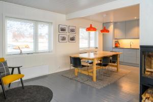 GimsøyLillevik Lofoten的厨房以及带木桌和椅子的用餐室。
