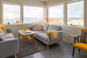 GimsøyLillevik Lofoten的带沙发、桌子和窗户的客厅
