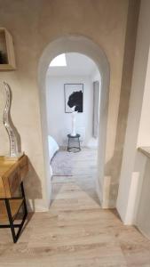SallauminesLa Tanière Lens est的走廊上设有拱门,房间内设有桌子