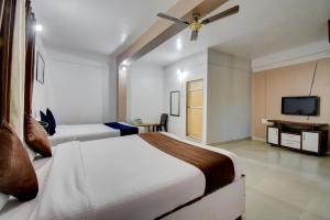 马哈巴莱斯赫瓦尔The Greenpark Retreat, Mahabaleshwar的一间卧室配有两张床和一台平面电视