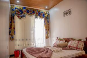 基加利Simaza Villa的一间卧室配有床和带窗帘的窗户