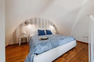 滨海波利尼亚诺Oltremare的一间卧室配有一张带蓝色棉被的床