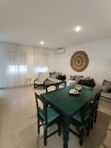 阿瓜阿马加Rinconcito en Aguamarga的客厅配有绿色的桌子和椅子