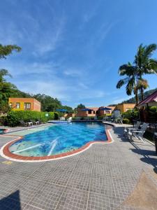 拉维加Hotel Campestre la Vega Inn的棕榈树度假村的游泳池