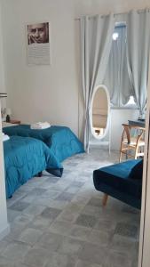 布里亚蒂科Residenza La Meridiana的一间卧室设有两张蓝色的床和窗户