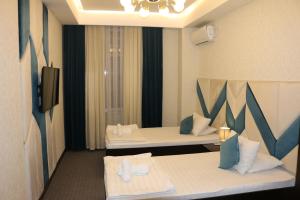 杜尚别Hotel Tajikgrey Dushanbe的一间酒店客房,设有两张床和电视