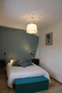 Faverolles-sur-CherLe Petit Saule - Gîte entre Beauval et Chenonceau的一间卧室配有一张床和一个吊灯