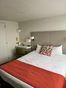 瑟堡The Originals City - Hotel Restaurant A Pic的一间卧室配有一张带红色毯子的大床