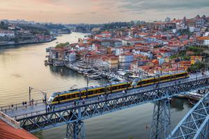 波尔图Holiday Inn Express Porto - Boavista, an IHG Hotel的河上桥上的火车