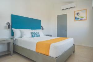 拉利伯塔德Hotel Roca Sunzal的一间卧室配有一张大床和蓝色床头板