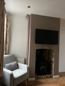 沃特福德Rickmansworth Lodge的客厅设有壁炉,上面配有电视