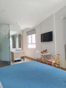 胡志明市7 Apartment的客房设有1张床、1张桌子和1台电视。