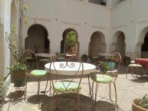 廷吉尔Hotel et Restaurant Riad Amodou的配有椅子、桌子和桌椅的房间