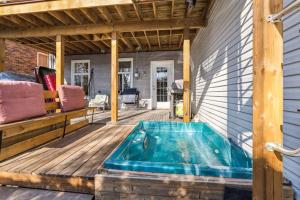 蒙特利尔Superbe maison à Montréal的木甲板上的热水浴池,带房子