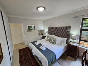 伯诺尼Jasmine Guest Cottage的一间卧室设有一张大床和一个窗户。
