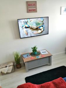 伯恩茅斯The Blue Crab in Bournemouth的客厅配有桌子和墙上的电视
