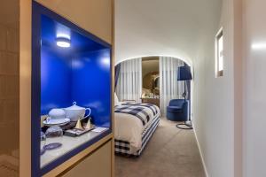 科英布拉Hästens Sleep Experience FLH Hotels Coimbra的一间设有蓝色客房的卧室,配有一张床和镜子