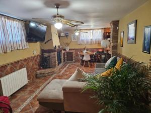迪拉尔Apto-en el Bajo de la casa-estilo rústico en Dílar的带沙发的客厅和用餐室