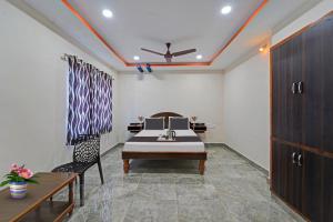 蒂鲁帕蒂Capital O Hotel Lakshmi Residency的配有床、桌子和椅子的房间