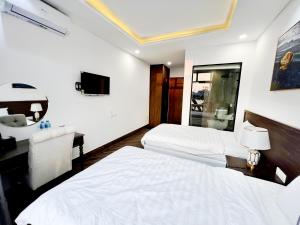 富国Legacy Phú Quốc的酒店客房配有两张床和一张书桌