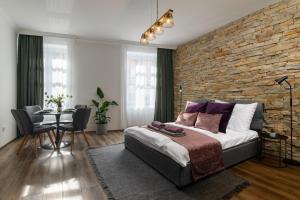 埃格尔Várvédőház Apartmanok Eger的卧室设有砖墙、一张床和一张桌子