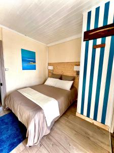 Solférinola maison des ateliers的一间卧室设有一张大床,拥有蓝白色的墙壁