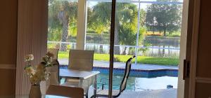 维洛海滩Luxury 3-Bedroom Home near Beaches with Pool的一间带桌椅的用餐室和一个游泳池