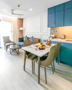 岘港Goldenbay Danang 1 Bedroom Apartment的厨房以及带桌椅的起居室。