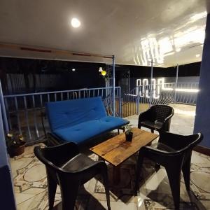 罗纳瓦拉Blue Lagoon 2bhk的阳台配有蓝色的沙发、椅子和桌子