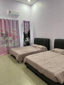 乌鲁地南Sanrio House - Taman Bestari indah的两张床铺,位于带窗帘的房间