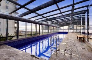 墨尔本Modern Comfort Meets City Skyline的一座带长凳游泳池的大型建筑