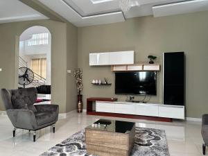 库马西Nanani Villa - Harmonious Paradise的客厅配有电视、沙发和椅子