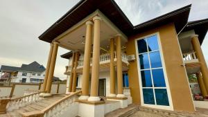 库马西Nanani Villa - Harmonious Paradise的房屋设有大窗户和柱子