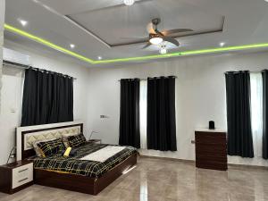 库马西Nanani Villa - Harmonious Paradise的一间卧室配有一张床和吊扇