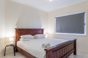 布里斯班Modern 2BR With Deck的卧室配有一张带白色床单的大床和窗户。