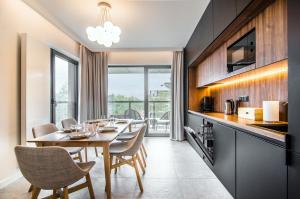 洛格沃Apartamenty Prezydenckie - Morski Szum - Alldayholiday的厨房以及带桌椅的用餐室。