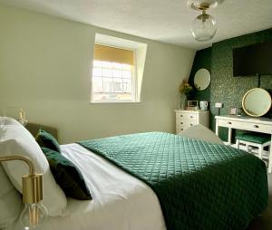 韦茅斯The Wadham的一间卧室配有一张带绿色和白色棉被的床