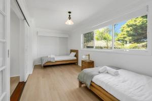 Albion ParkLakeside Family Oasis - Oak Flats的一间卧室设有两张床和窗户。