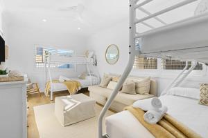 Long JettyCoastal Retreat Long Jetty- Toowoon Bay的一间白色的卧室,配有双层床和一间客厅