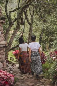 乌鲁班巴Logde Casa de campo & Retreat Center的两个女人在花园里的小路前行