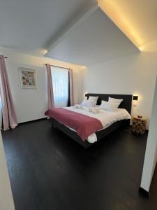 比桑Hôtel Restaurant & Spa du Tremplin的一间卧室配有一张带红色毯子的大床