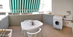 加利波利La Spiaggia sotto Casa的洗衣房配有桌子和洗衣机