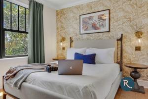 迈阿密Roami at Tower Hotel的一间卧室配有一张带笔记本电脑的床