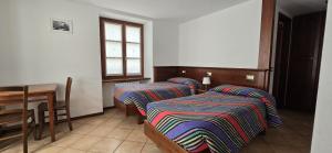 斯科佩洛阿尔坎图兹欧酒店的客房设有两张床、一张桌子和一扇窗户。
