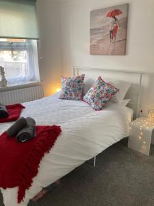 浦耳The Sashes - Apartment One - FREE Parking - Ultrafast WIFI - Smart TV - Netflix - sleeps up to 6! Close to Poole Town Center & Sandbanks & Bournemouth的一间卧室配有带枕头和雨伞的床