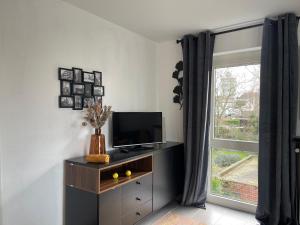 蒂尔特Appartamento ideal的一间带电视和窗户的客厅