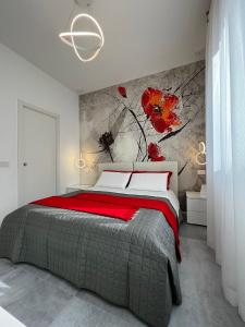科尔西科B&B Prestige的卧室配有一张大床,墙上挂着红色鲜花