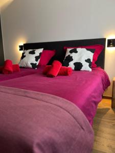 比桑Hôtel Restaurant & Spa du Tremplin的一张带黑白牛枕头的床